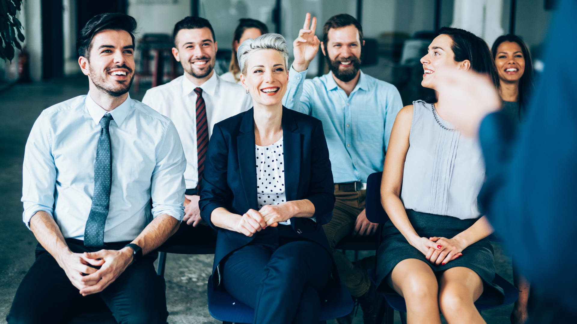 Grupa ludzi siedzących na krzesłach w sali.1