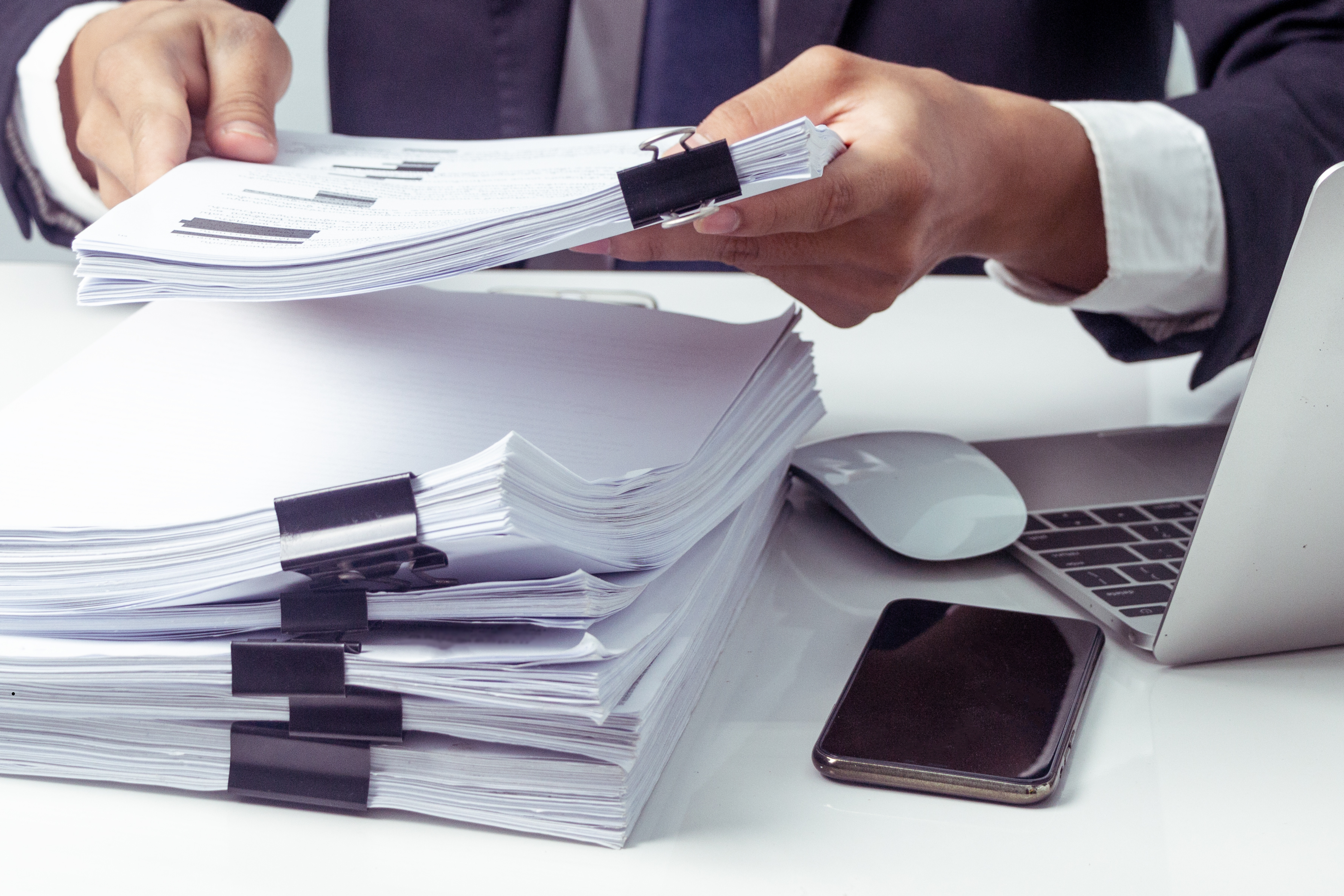 Ręce mężczyzny trzymające plik dokumentów.1