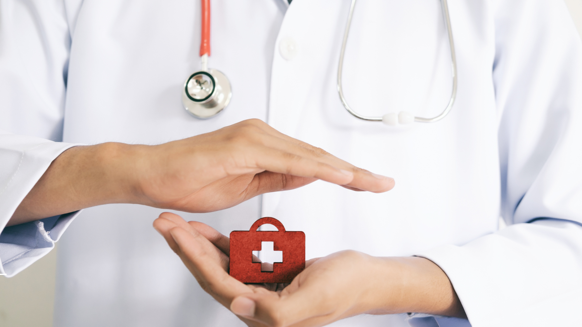 Grafika przedstawia dłonie lekarza trzymającego malutką apteczkę.1