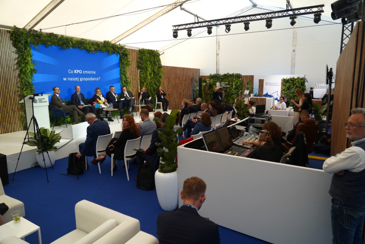 Panel dyskusyjny na scenie w pawilonie Ministerstwa Funduszy i Polityki Regionalnej.